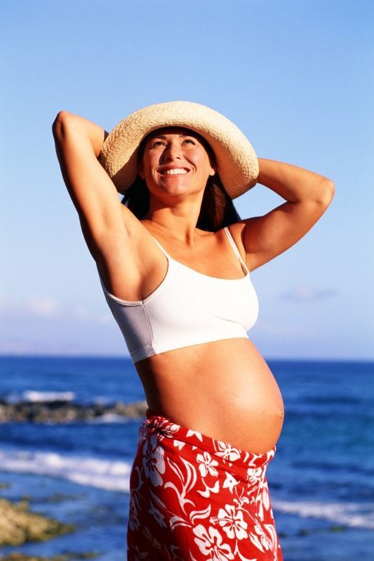 Těhotná žena na pláži