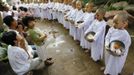 Novice Thai nuns stand in line to receive food at the Sathira Dammasathan Buddhist meditation centre in Bangkok