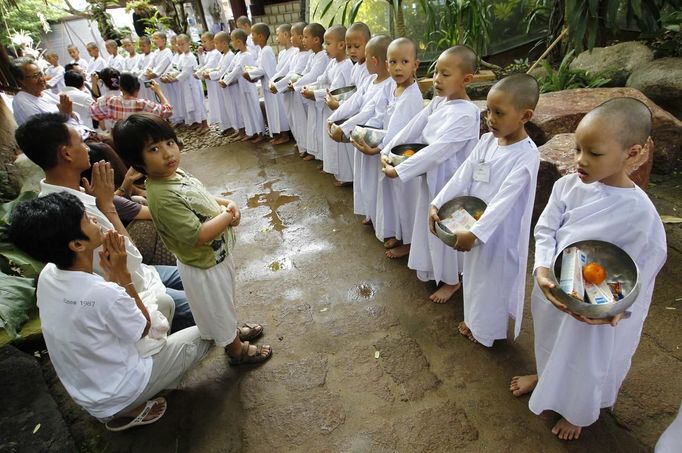 Novice Thai nuns stand in line to receive food at the Sathira Dammasathan Buddhist meditation centre in Bangkok