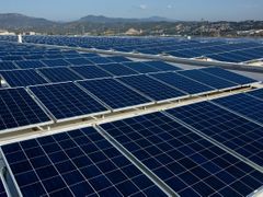 Solární panely na střechách výrobního závodu a krytých parkovištích.
