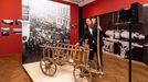 Kurátor ústeckého muzea Jiří Preclík ukazuje vozík pro tažné psy před Jenatschkeho fotografií Odvod psů z roku 1916.