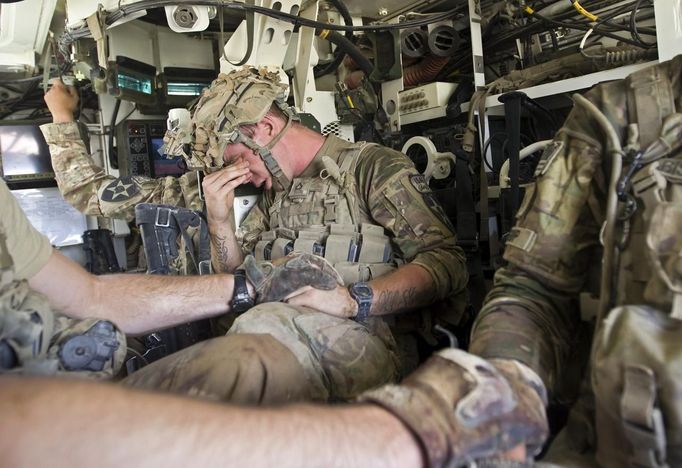 A U.S. Army soldier reacts as he sits inside an armoured vehicle after his comrade, Sgt. Matt Krumwiede, was wounded by an improvised explosive device (IED) in southern Afghanistan in this June 12, 2012 file photo. On June 12, 2012, Krumwiede was on patrol in Afghanistan when he stepped on an IED, which tore away both his legs, damaged his left arm, and ripped open his abdominal cavity. The 22-year-old has since undergone around 40 surgeries and is learning to walk with prosthetic legs. He is keen to re-join the infantry as soon as his injuries allow. U.S. troops have been in Afghanistan since 2001. Thousands of Afghan elders gathered in Kabul on November 21, 2013 at a Loya Jirga, or grand council, to debate a crucial security pact with the United States, a day after Kabul and Washington reached a draft agreement laying out the terms under which U.S. troops may stay beyond 2014. Picture taken June 12, 2012.