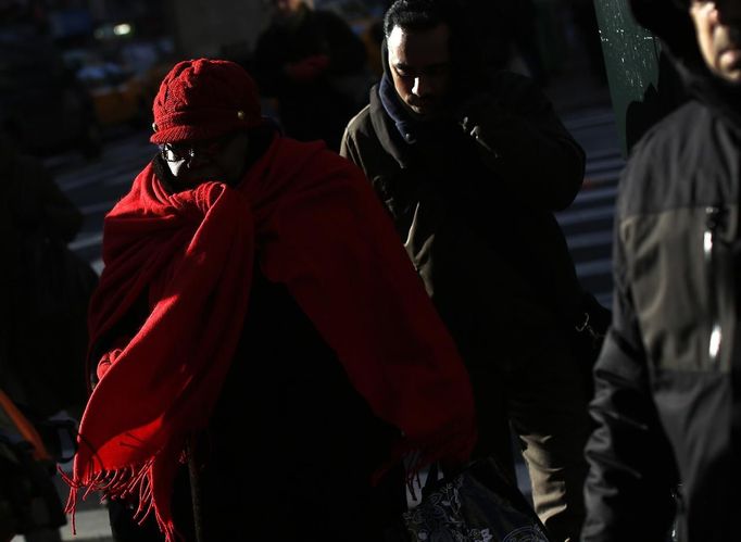 People walk along 7th avenue in New York January 23, 2013. An Arctic blast gripped the U.S. Midwest and Northeast on Tuesday, with at least three deaths linked to the frigid weather, and fierce winds made some locations feel as cold as 50 degrees below zero Fahrenheit. (minus 46 degrees Celsius). REUTERS/Shannon Stapleton (UNITED STATES - Tags: ENVIRONMENT SOCIETY) Published: Led. 23, 2013, 3:16 odp.