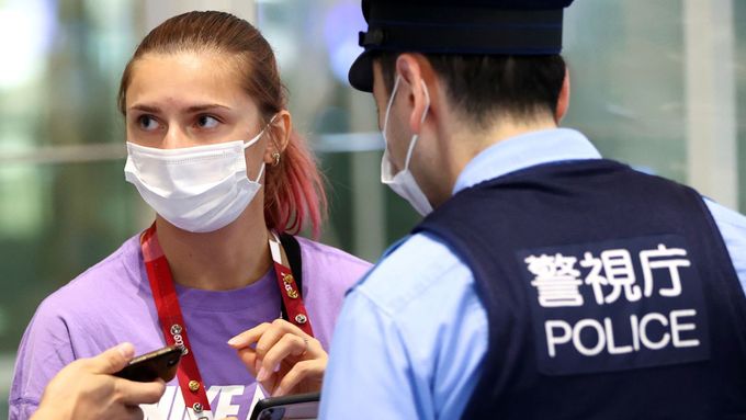 Běloruská běžkyně Kryscina Cimanouská mluví na tokijském letišti s japonskými policisty