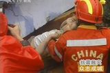 Záchranáři vytahují několik dní po zemětřesení z trosek malé dítě, kterému se podařilo přežít.