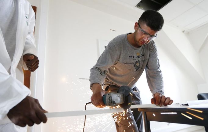 Unemployed Belgian Mohamed Sammar works in a renovation site, part of the "Fit for a job" programme which includes a week-long work placement and aims to consolidate his previous work experience, in Brussels June 19, 2013. Sammar, 27, has been looking for a job in the construction sector for 2 years. "Fit for a job" is the initiative of former Belgian boxing champion Bea Diallo, whose goal was to restore the confidence of unemployed people and help them find a job through their participation in sports. Picture taken June 19, 2013. REUTERS/Francois Lenoir (BELGIUM - Tags: SPORT BOXING SOCIETY BUSINESS EMPLOYMENT) Published: Čec. 5, 2013, 4:44 odp.