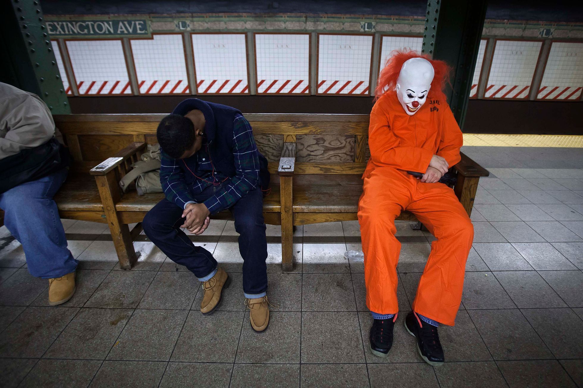 Halloween reveller and other people sleep in the subway early in the morning in the Manhattan borough of New York