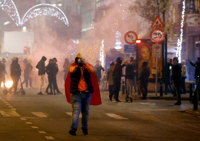 Soccer Football - FIFA World Cup Qatar 2022 - Fans in Brussels watch France v Morocco - Brussels, Belgium - December 14, 2022 A Morocco fan is pictured with a flare after