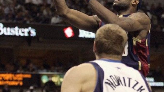 Basketbalista Clevelandu Cavaliers LeBron James (vpravo) zakončuje v zápase NBA proti Dallasu Dirka Nowitzkého (vpředu).