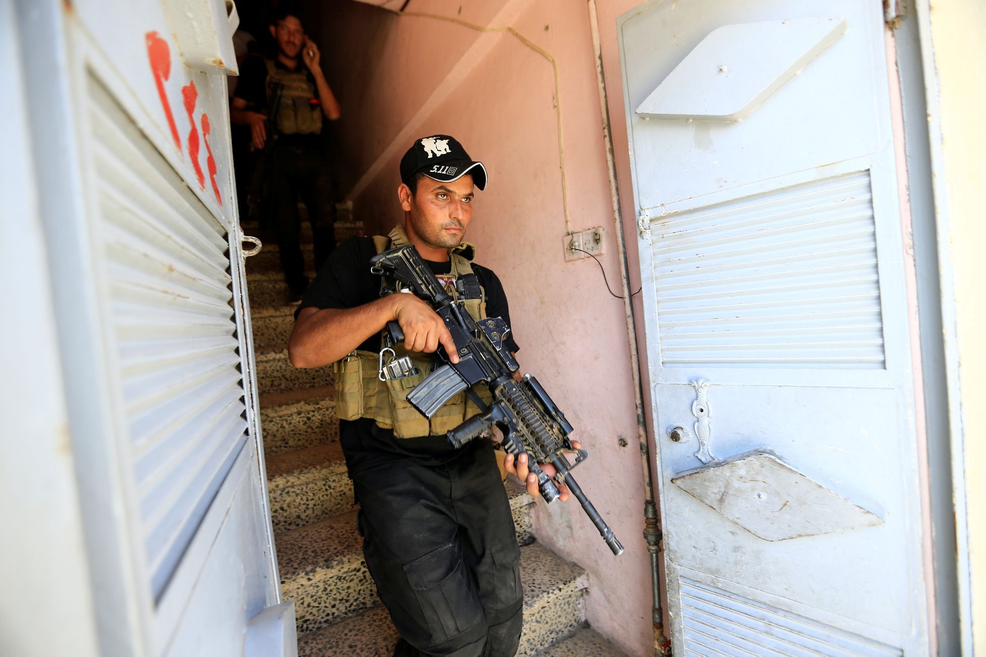 Irácký voják obhlíží jeden z domů v Mosulu.