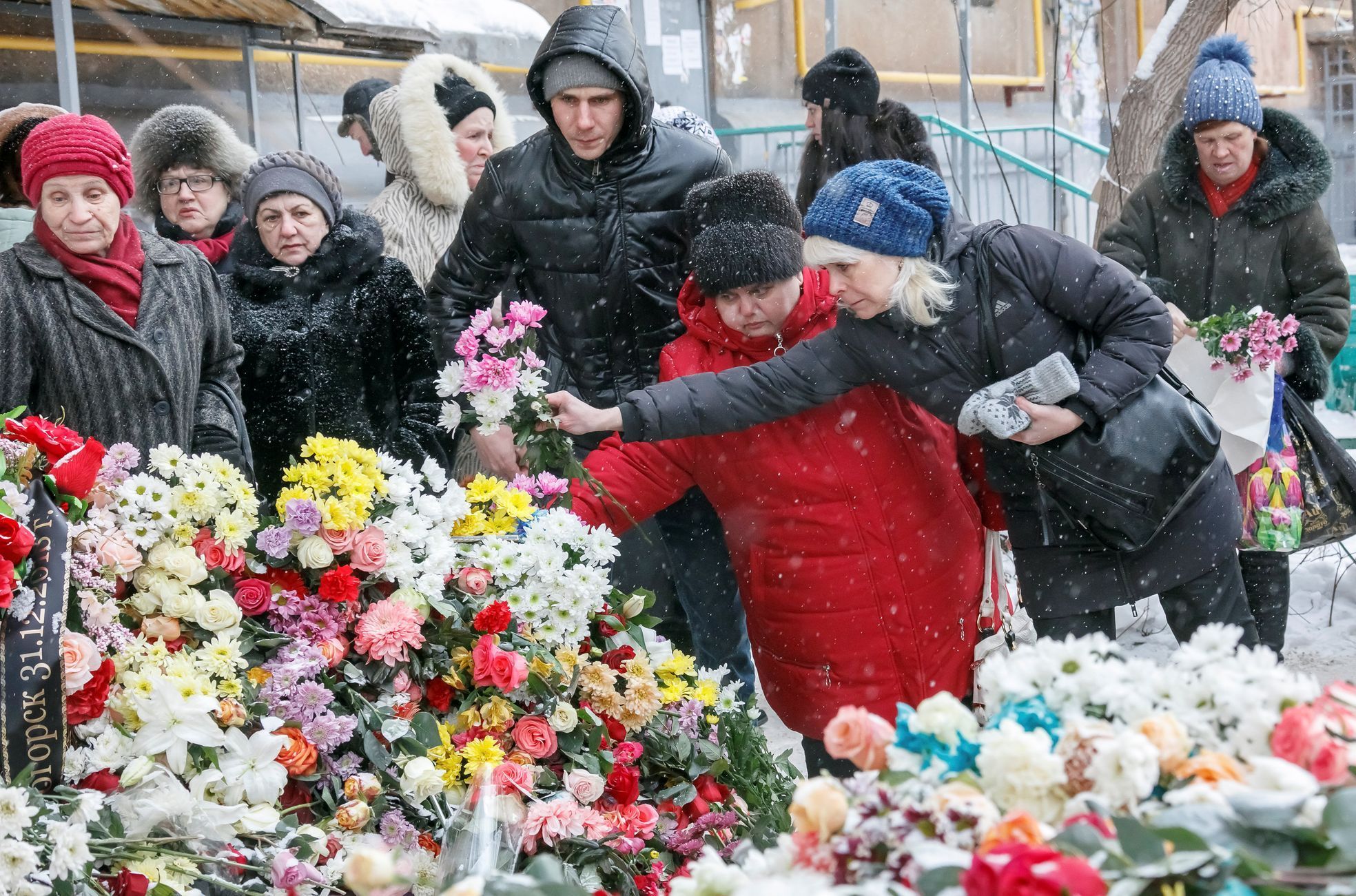 Obyvatelé Magnitogorsku přinášejí květiny k pietnímu místu u zříceného domu, v jehož troskách zemřelo 39 lidí