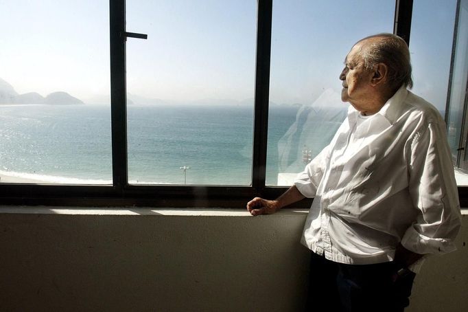 Brazilian architect Oscar Niemeyer looks at the Copacabana beach from his office after his interview with Reuters in Rio de Janeiro, in this June 16, 2003 file photo. Niemeyer, a towering patriarch of modern architecture who shaped the look of contemporary Brazil and whose inventive, curved designs left their mark on cities worldwide, died late on December 5, 2012. He was 104. Niemeyer had been battling kidney and stomach ailments in a Rio de Janeiro hospital since early November. His death was the result of a lung infection developed this week, the hospital said, little more than a week before he would have turned 105. REUTERS/Sergio Moraes/Files (BRAZIL - Tags: OBITUARY SOCIETY) Published: Pro. 6, 2012, 2:29 dop.