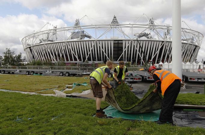 Workers prepare membrane covered with meadow flowers and turf outside the Olympic Stadium ahead of the Opening Ceremony in the London 2012 Olympic Park at Stratford in London July 13, 2012. REUTERS/Luke MacGregor (BRITAIN - Tags: SPORT OLYMPICS) Published: Čec. 13, 2012, 4:16 odp.