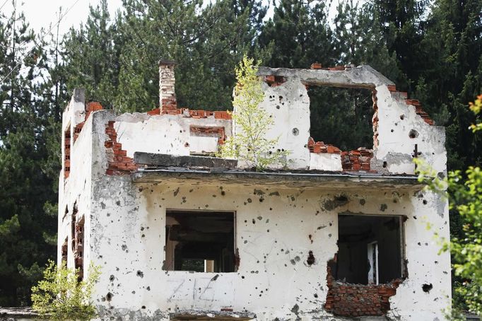 The ruins of a home are pictured in the villages near Srebrenica July 6, 2012. The ghostly town is packed with people only on the anniversary of the massacre, when families come to bury remains that are still being recovered and commemorate the victims. But the town, which a few years ago was a jumble of burnt-out buildings and empty streets, is now slowly coming back to life. New and rebuilt houses are starting to replace the ruins of the last decade and more children are playing in the streets. However, today Srebrenica Muslims and Serbs still hold each other in deep distrust. The local government and international donors have promised millions of euros for the recovery of the town, which to the dismay of Muslims now lies in territory ceded to Bosnia's Serb Republic after the 1992-95 Bosnian War. But many Muslims are still waiting for those pledges to take hold. Picture is taken on July 6, 2012. REUTERS/Dado Ruvic (BOSNIA AND HERZEGOVINA - Tags: CONFLICT SOCIETY) Published: Čec. 8, 2012, 3:29 dop.