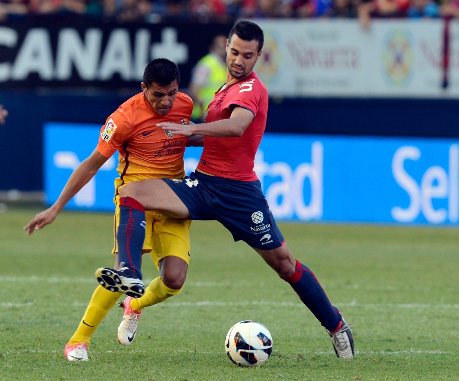 Fotbalista Barcelony Alexis Sánchez (vlevo) bojuje o míč s Miguelem Fianem v utkání La Ligy 2012/13 s Osasunou.