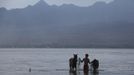 A man walks with his horses after washing them following a race at Kalaki beach on the outskirts Bima, on Indonesia's Sumbawa island, November 18, 2012. Dozens of child jockeys, some as young as eight-years-old take part in the races. Involving nearly 600 horses they take place around a dusty, oval track of 1,400 meters (nearly one mile). The reward, for the winner is a handful of cash for his family, and glory for the jockey. The grand prize is one million rupiah ($100). Those who win their groups get two cows. The chairman of the races' organising team, Hajji Sukri, denies that there is any danger to the children saying they are all skilful riders and none has been killed or seriously hurt. Picture taken November 18, 2012. REUTERS/Beawiharta (INDONESIA - Tags: SPORT SOCIETY) ATTENTION EDITORS: PICTURE 1 of 25 FOR PACKAGE 'BETTING ON CHILD JOCKEYS' Published: Lis. 24, 2012, 9:15 dop.