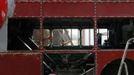 Artist David Cerny gestures at a factory hall in Prague as he works on his project to transform a London bus into a robotic sculpture May 22, 2012. The bus, which Cerny hopes could become an unofficial mascot of the London 2012 Olympic Games, does push-ups with the help of an engine powering a pair of robotic arms and the motion is accompanied by a recording of sounds evoking tough physical effort. It will be parked outside the Czech Olympic headquarters in London for the duration of the Games. Picture taken May 22, 2012. REUTERS/Petr Josek (CZECH REPUBLIC - Tags: SOCIETY SPORT OLYMPICS TRANSPORT) Published: Čec. 22, 2012, 5:47 odp.