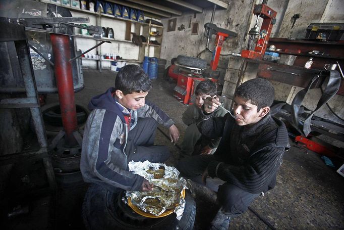 Gaza child labour 2012-02-23 00:00:00 epa03119003 Palestinian children having their lunch in a car repair workshop in the town of Beit Lahyia in northern Gaza on 23 February 2012. Reports state that child labor is widespread in the Gaza Strip because of the high rate of poverty and unemployment. Palestinain children leave school and go to work in an attempt to improve their standard of living, for low salaries because of lack of employment opportunities in Gaza. EPA/ALI ALI