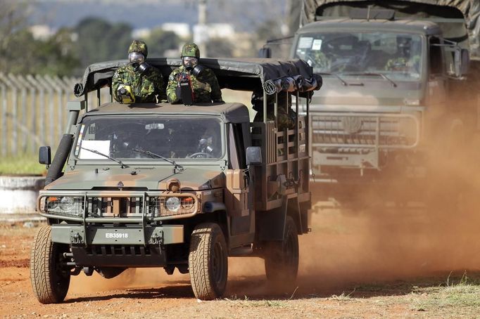 Brazilian army soldiers wearing chemical suits participate in an anti-terror simulation exercise as part of the preparation for the upcoming 2013 FIFA Confederations Cup in Brasilia. May 22, 2013. About 100 soldiers took part in the exercise which include preventive strikes against chemical, biological and radiological weapons conducted around Mane Garrincha National Stadium, according to an official statement. REUTERS/Ueslei Marcelino (BRAZIL - Tags: SPORT SOCCER MILITARY) Published: Kvě. 22, 2013, 9:39 odp.