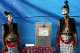 Volební úředníci, oblečení jako komediální postavy z jávanské hry "wayang", hlídají volební místnost v obci Solo, centrální Jáva.