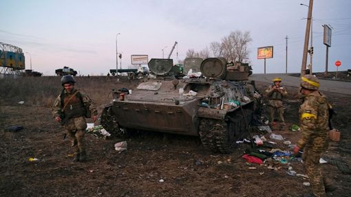 Ukrajinští vojáci u zničeného obrněného vozidla, které podle nich patřilo ruské armádě.