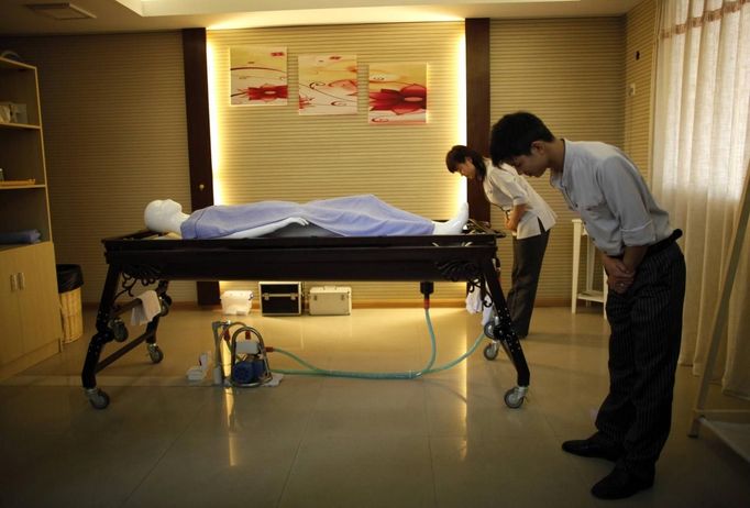 Students from Tianquanjiajing Funeral Service school bow in front of a plastic mannequin as they begin an undertaker service class in Jiaxing, Zhejiang province May 29, 2012. A new breed of young Chinese undertakers are fighting centuries-old taboos to gain social acceptance for their profession, saying they help the deceased and their families make their final parting with respect. There are more than 1,500 students across the country studying to become undertakers each year. Courses in funeral services take three years to complete and the service includes washing of the dead body as well as providing funeral make-up and dressing. Picture taken on May 29, 2012. REUTERS/Carlos Barria (CHINA - Tags: SOCIETY) ATTENTION EDITORS - PICTURE 02 OF 17 FOR PACKAGE 'FUNERAL SERVICE STUDENTS' Published: Čer. 7, 2012, 2:43 dop.