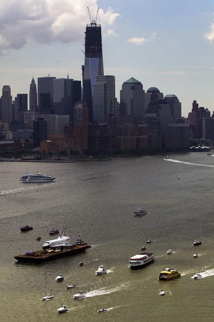 The Space Shuttle Enterprise floats up the Hudson River June 6, 2012, past the New York skyline as it rides on a barge to be placed at the Intrepid Sea, Air and Space Museum. REUTERS/Lucas Jackson (UNITED STATES - Tags: SCIENCE TECHNOLOGY TRANSPORT) Published: Čer. 6, 2012, 4:37 odp.