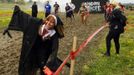 A zombie in nun's clothing chases runners on the "Run for Your Lives" 5K obstacle course race in Amesbury, Massachusetts May 5, 2012. Runners face man-made and natural obstacles on the course, while being chased by zombies, who try to take "health" flags off the runners belts. REUTERS/Brian Snyder (UNITED STATES - Tags: SPORT SOCIETY) Published: Kvě. 5, 2012, 11:15 odp.