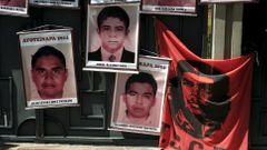 Pictures of the 43 Mexican students who disappeared a year ago are seen hung up near a banner of a revolutionary leader Che Guevara, on the entrance gate of the Mexican embassy in La Paz, Bolivia