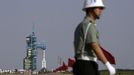 A soldier patrols in front of the launch pad holding a Long March II-F rocket loaded with a Shenzhou-9 manned spacecraft carrying Chinese astronauts Jing Haipeng, Liu Wang and Liu Yang before its launch at the Jiuquan Satellite Launch Center, Gansu province June 16, 2012. China launched the spacecraft putting its first woman, 33-year-old female fighter pilot Liu Yang, in orbit on Saturday as the country takes its latest step towards building a space station within the decade. REUTERS/Jason Lee (CHINA - Tags: MILITARY SCIENCE TECHNOLOGY) Published: Čer. 16, 2012, poledne