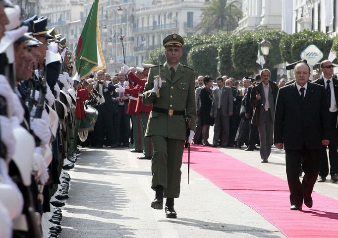 Prezident Abdalazíz Buteflika (vpravo) kráčí po červeném koberci do stanice, aby zahájil provoz metra.