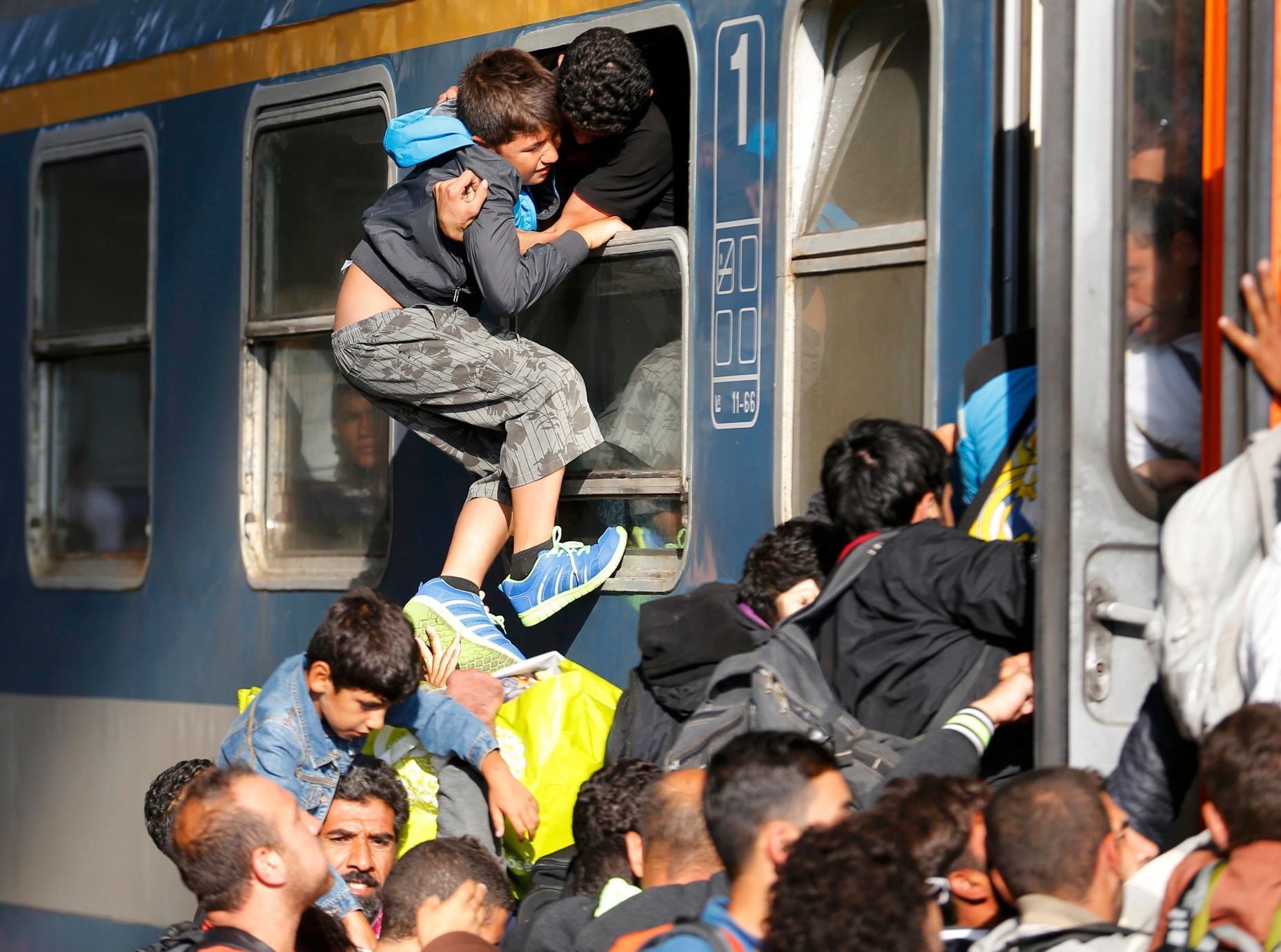 Uprchlíci se snaží nasednout do vlaku v Keleti