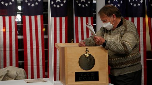 Muž vybírá hlasy z urny, které předčasně odevzdali voliči v hotelu v New Hampshire.