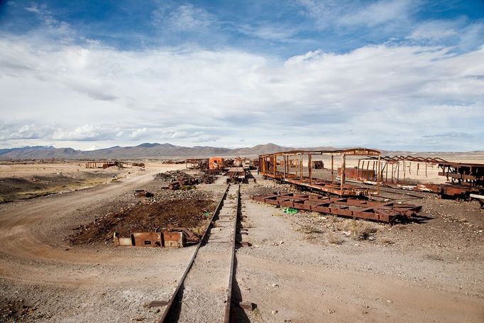 popis: Train cemetery, Uyuni, Bolivia - Apr 2012 2012-04-15 00:00:00 Mandatory Credit: Photo by Stefan Jeremiah / Rex Features (1823223s) Rust In Peace Sitting 3,670 metres above sea level on the edge of the world's largest salt flat are a group of rusted locomotives that once represented the cutting edge of Victorian engineering. Towards the end of the 19th century British engineers were tasked with helping build railway networks all over South America. And when it came to investing in a good transport network the Bolivian Government relied on British expertise. Today, Uyuni in southweat Bolivia is the gateway to the spectacular Salar de Uyuni salt flats. However, it is also, and historically has always been, an important transport hub. Towards the end of the 1800s the plan was to turn it into the main distribution centre for trains carrying freshly mined minerals down to the ports on the Pacific Ocean. Construction on the railway began in 1888 and, despite the efforts of local Aymara Indians to sabotage it, ended in 1892. However, technical and geographical difficulties and disputes with neighbouring countries, which ultimately left Bolivia landlocked, all took their toll and the full grand plans for Uyuni were never realised. Instead the mining industry limped on until the 1940s before ultimately collapsing. Rather than being decommissioned and sold as scrap the now redundant locomotives were driven 3km outside of town and dumped in the desert. As the railwaylines fell into disrepair, the weatherbeaten metal carcases were simply left to rot under the hot sun. Today these rusted behemoths form an eerie "train cemetery" - ghostly skeleton of a bygone age. MUST CREDIT PHOTOS BY: Stefan Jeremiah / Rex Features For more information visit http://www.rexfeatures.com/stacklink/IXJAYEVLX