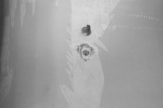 Šmírovací otvor ve zdi domu na adrese 21 Rue Le Sueur v Paříži, který používal sériový vrah Dr. Marcel Petiot ke sledování umírajících obětí. Fotografie z roku 1946.