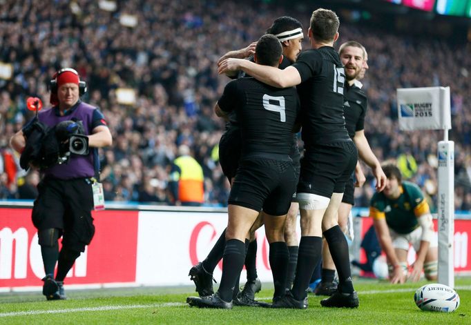 Jerome Kaino of New Zealand (2ndL) celebrates with temmates after scoring a try during their Rugby World Cup Semi-Final match against South Africa at Twickenham in London