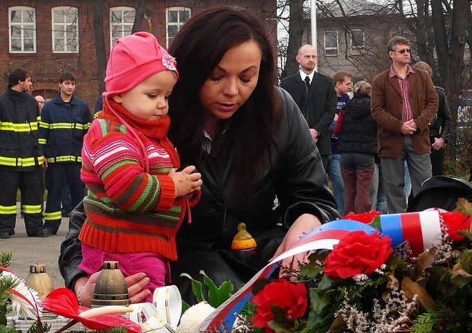 Plocha dlážděného čtverce pro budoucí pomník se postupně plnila květinami a svíčkami. A lidé přinášeli další