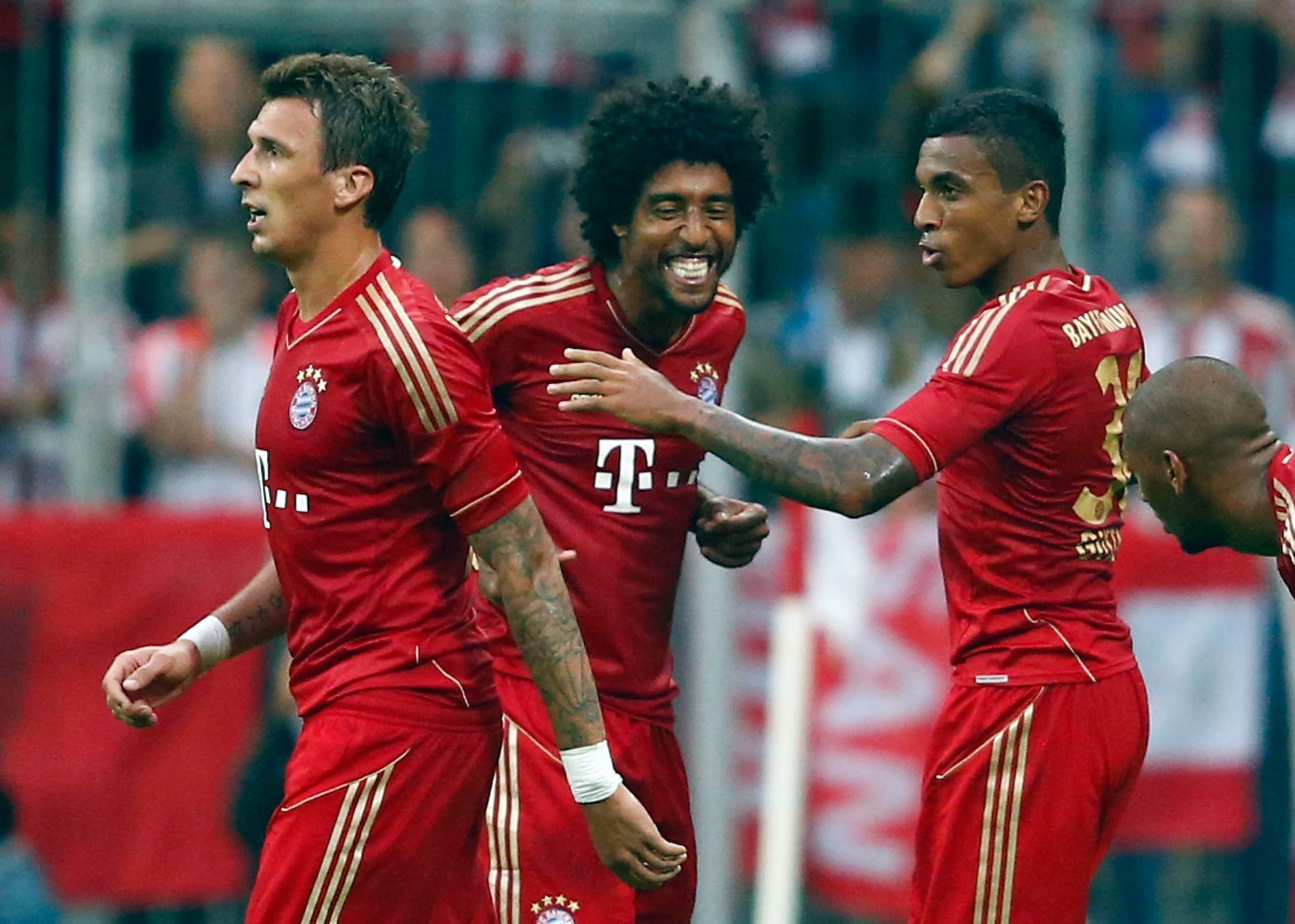 Hráči Bayernu Mnichov Mandžukič, Dante a Gustavo slaví gól do sítě Stuttgartu