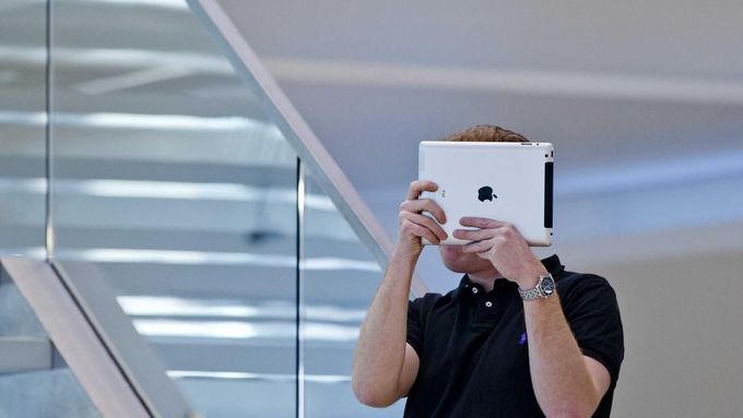 Zaměstnanec prodejny v Berlíně si pomocí tabletu fotografuje dav zákazníků. Nový iPad má 5megapixelový fotoaparát, který umožňuje pořizovat snímky při horších světelných podmínkách. Fotografie by mělo být možné snáze třídit a retušovat pomocí prstových štětců.