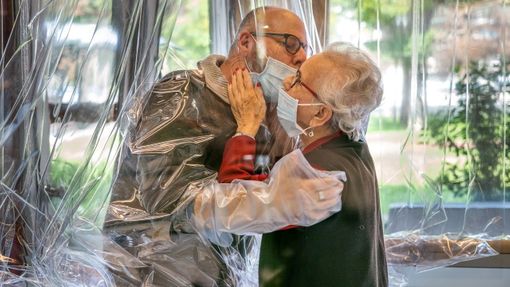 V domově seniorů v Itálii mohou během epidemie rodiny navštívit tamní klienty přes speciální průhlednou bariéru.