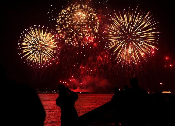 People watch as fireworks explode over San Francisco Bay during the 75th anniversary celebration of the Golden Gate Bridge in San Francisco, California May 27, 2012. REUTERS/Robert Galbraith (UNITED STATES - Tags: ANNIVERSARY SOCIETY) Published: Kvě. 28, 2012, 5:35 dop.