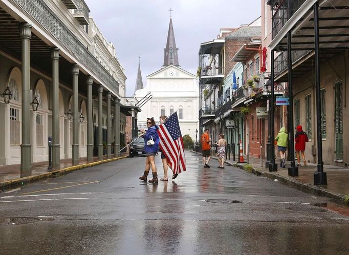 Shelly Ackel of New Orleans carries an American flag through the French Quarter as Hurricane Isaac approaches New Orleans, Louisiana August 28, 2012. For New Orleans, Tuesday morning brought an all-too-familiar dilemma: to flee or not to flee. With Hurricane Isaac bearing down on the low-lying city, residents scrambled to either leave or gather supplies to weather the storm. REUTERS/Jonathan Bachman (UNITED STATES - Tags: ENVIRONMENT DISASTER) Published: Srp. 28, 2012, 7:31 odp.