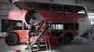 Artist David Cerny cuts a component of his sculpture at a factory hall in Prague as he works on his project to transform a London bus into a robotic sculpture May 9, 2012. The bus, which Cerny hopes could become an unofficial mascot of the London 2012 Olympic Games, does push-ups with the help of an engine powering a pair of robotic arms and the motion is accompanied by a recording of sounds evoking tough physical effort. It will be parked outside the Czech Olympic headquarters in London for the duration of the Games. Picture taken May 9, 2012. REUTERS/David W Cerny (CZECH REPUBLIC - Tags: SOCIETY SPORT OLYMPICS TRANSPORT) Published: Čec. 22, 2012, 5:48 odp.