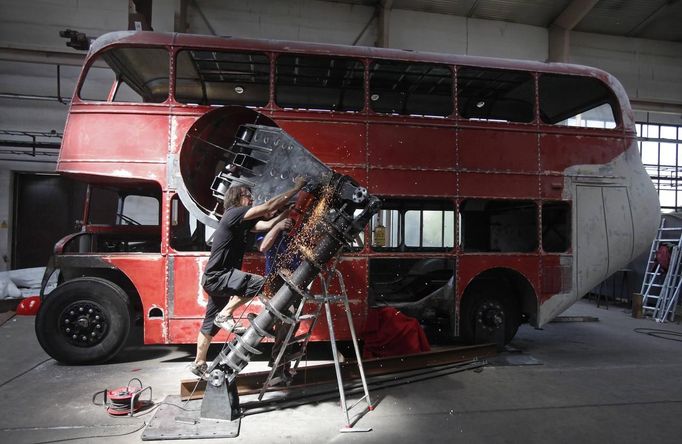 Artist David Cerny cuts a component of his sculpture at a factory hall in Prague as he works on his project to transform a London bus into a robotic sculpture May 9, 2012. The bus, which Cerny hopes could become an unofficial mascot of the London 2012 Olympic Games, does push-ups with the help of an engine powering a pair of robotic arms and the motion is accompanied by a recording of sounds evoking tough physical effort. It will be parked outside the Czech Olympic headquarters in London for the duration of the Games. Picture taken May 9, 2012. REUTERS/David W Cerny (CZECH REPUBLIC - Tags: SOCIETY SPORT OLYMPICS TRANSPORT) Published: Čec. 22, 2012, 5:48 odp.