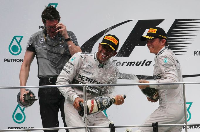 Mercedes Formula One driver Lewis Hamilton of Britain (C) celebrates on the podium with team mate second-placed Nico Rosberg of Germany and team engineer Andrew Shovlin (