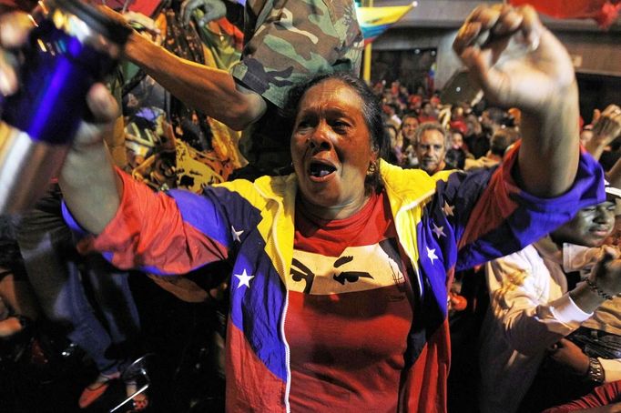 Supporters of Venezuelan President Hugo Chavez cheer as he appears on a balcony of the Miraflores Palace in Caracas October 7, 2012. Venezuela's socialist President Chavez won re-election in Sunday's vote with 54 percent of the ballot to beat opposition challenger Henrique Capriles. REUTERS/Tomas Bravo (VENEZUELA - Tags: POLITICS ELECTIONS) Published: Říj. 8, 2012, 5:55 dop.