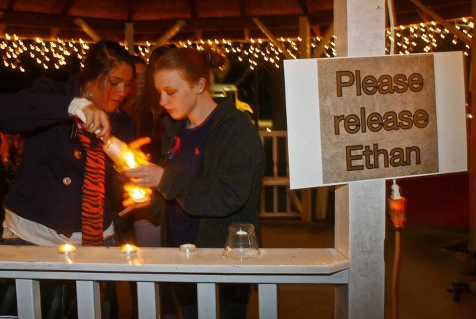 Mileah Lomaneck and Whitley Riley light candles during a candlelight vigil at City Hall in Midland City, Alabama, January 31, 2013. The vigil honored the memory of bus driver Charles Poland, and showed support for the release of a five-year-old boy held hostage in a bunker by Poland's alleged killer. REUTERS/Phil Sears (UNITED STATES - Tags: CRIME LAW) Published: Úno. 1, 2013, 2:29 dop.