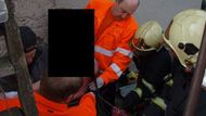Hasiči vyprošťují ženu, která se po pádu ze schodů nabodla na plot