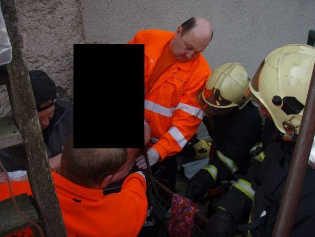 Hasiči vyprošťují ženu, která se po pádu ze schodů nabodla na plot