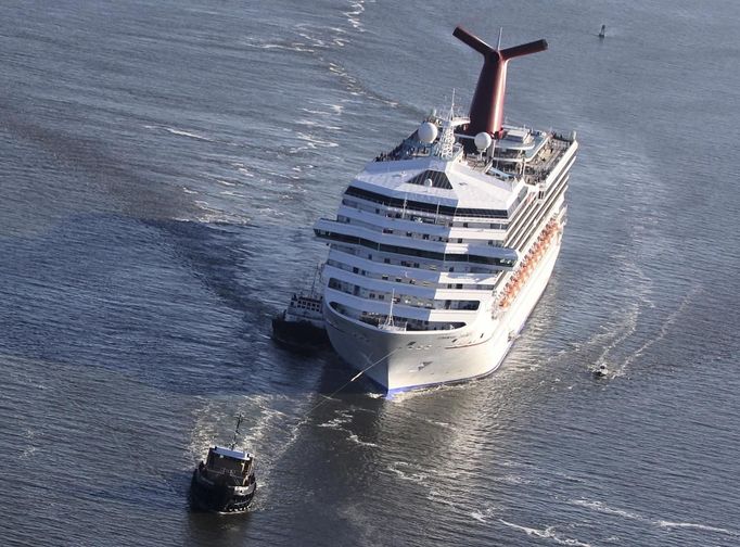 The Carnival Triumph cruise ship is towed towards the port of Mobile, Alabama, February 14, 2013. The 893-foot (272 meter) vessel, notorious for reports of raw sewage from overflowing toilets, has been without propulsion and running on emergency generator power since Sunday, when an engine room fire left it adrift in the Gulf of Mexico. REUTERS/ Lyle Ratliff (UNITED STATES - Tags: SOCIETY HEALTH TRAVEL MARITIME TRANSPORT BUSINESS) Published: Úno. 14, 2013, 11:54 odp.